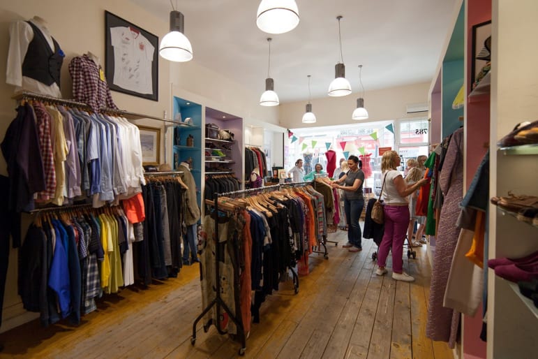 A photo of the inside of the Fulham shop including rails and some customers