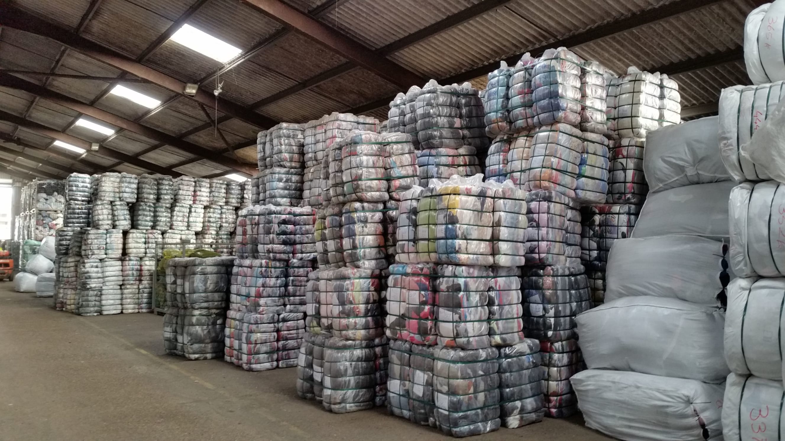 Piles of vacuum packed pre-sorted clothes in a warehouse