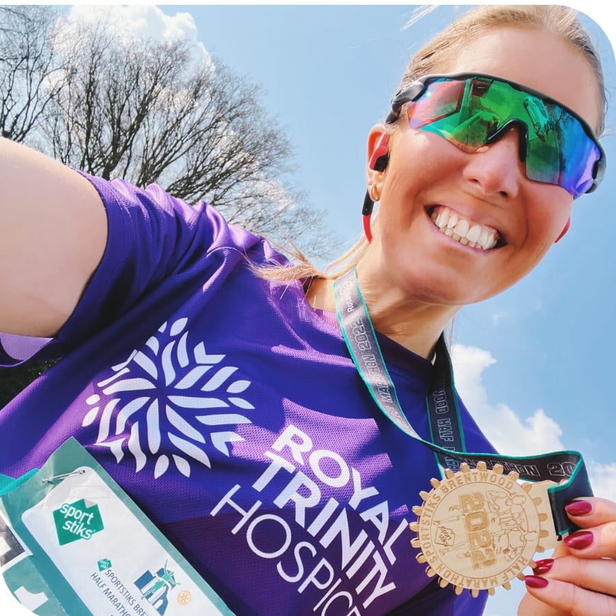 Anna holding a medal after completing a half marathon race
